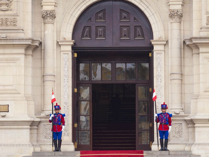 Two Peruvian Presidential Guards stand at attention on either side of the entrance to the Presidential Palace in Lima, Peru.