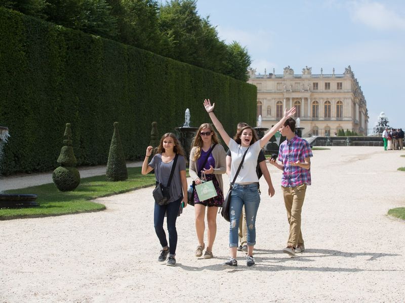 Five young adults visiting the Palace of Versailles.