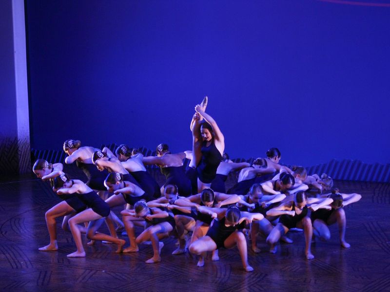 Group of young dancers in a unique pose on stage