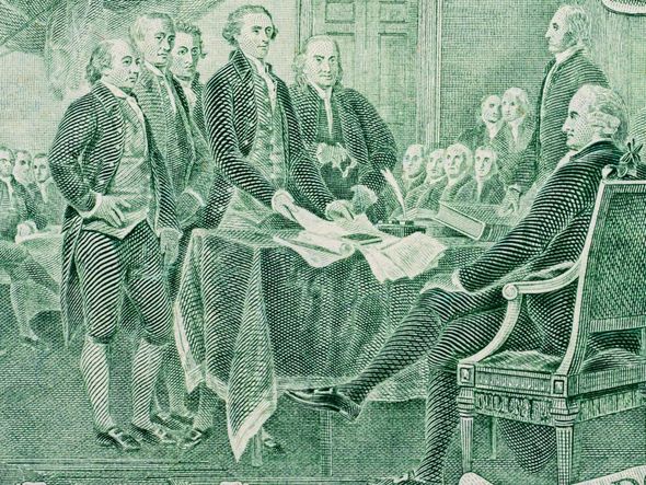 A close-up of the engraved image of the signing of the Declaration of Independence on a US two dollar bill.