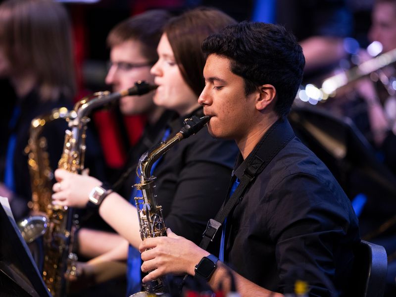 A group of young adults playing saxophone in a concert