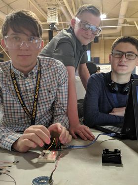 Three students working on a coding project.