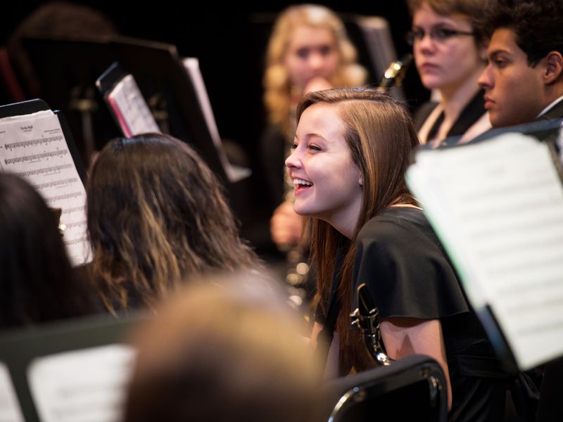 Teenage girl in band smiling during performance