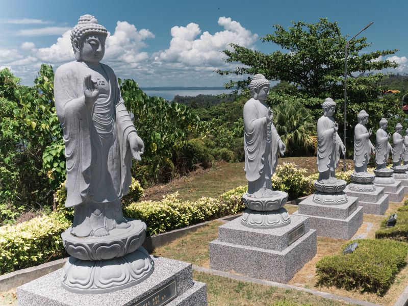 A row of Buddha statues on a hillside in Koh Samui, Thailand.