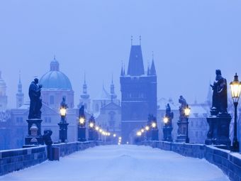 The Charles Bridge in Prague, Czech Republic covered in snow at dawn.