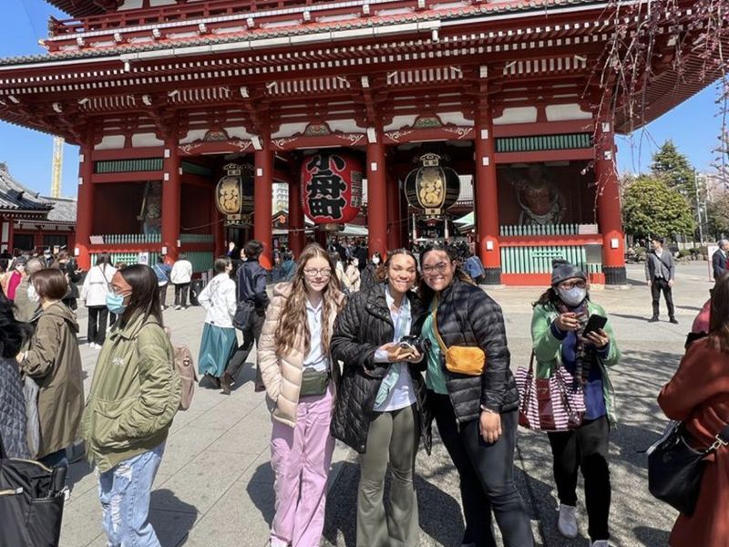 Four young adults posing in front of Sensoji Temple in Tokyo.