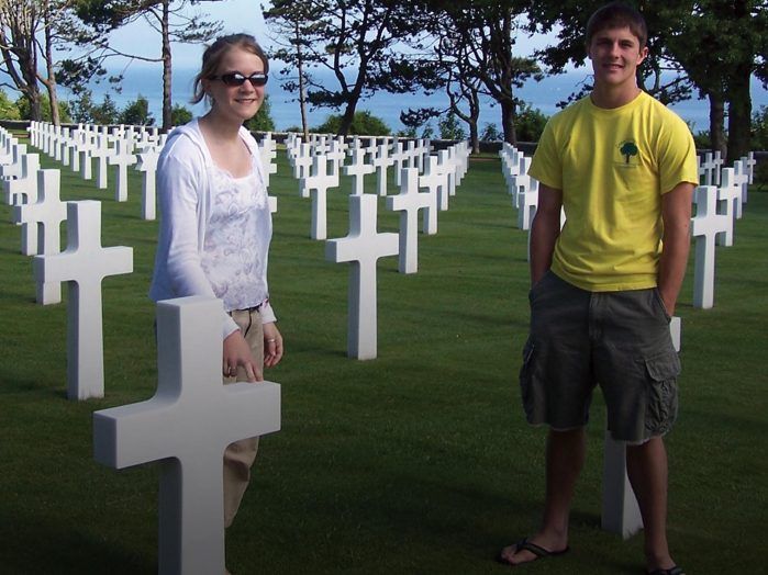 Two young adults visit the Normandy American Cemetery and Memorial in France, a poignant reminder of the sacrifices made during World War II.