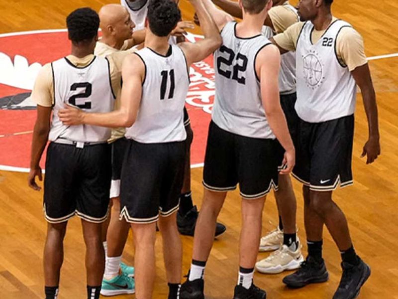 A basketball team huddles on the court.