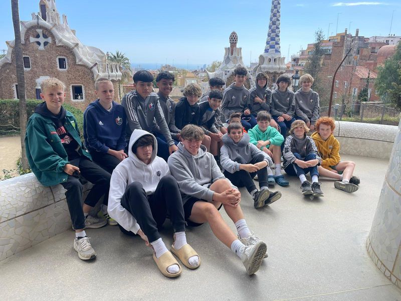 Group of teenage boys posing for a photo at Park Güell in Barcelona, Spain.