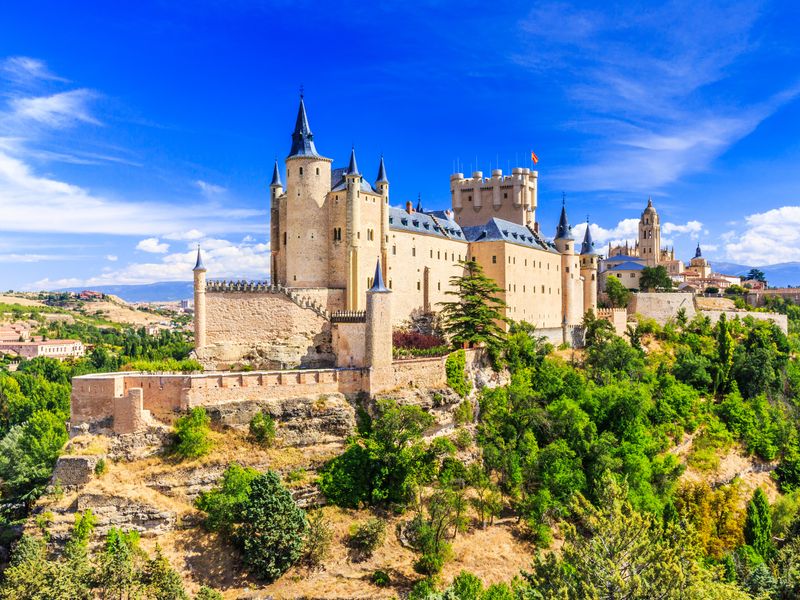 The Alcázar of Segovia, a medieval castle in Spain, under a clear blue sky.