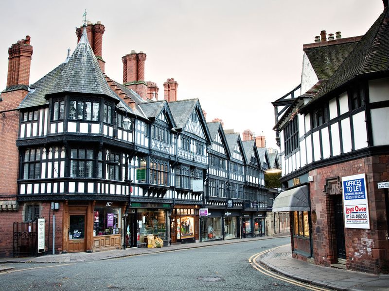 Historic black and white Tudor-style buildings line a street in Chester, England.