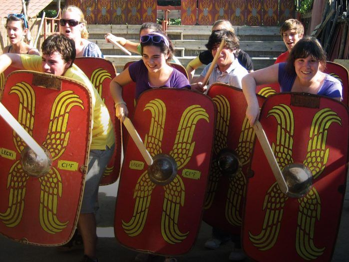 Group of young people reenacting a Roman soldier scene.