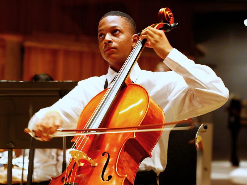 Young musician playing the cello with passion during a concert.