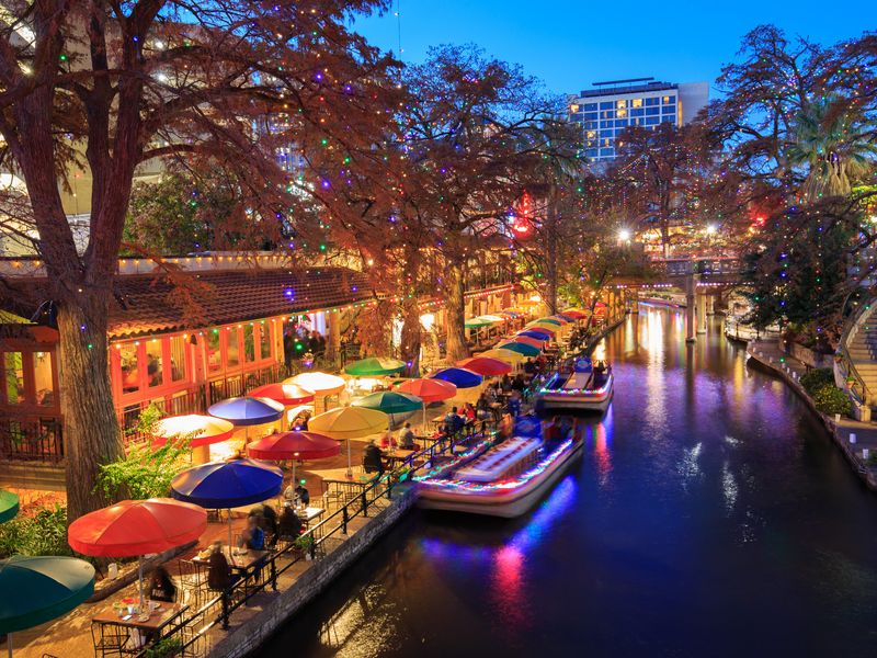 The San Antonio Riverwalk decorated for the holidays at night.