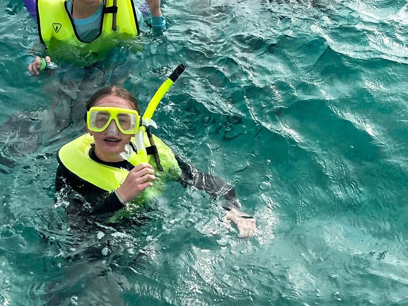 Three young people snorkeling in the ocean