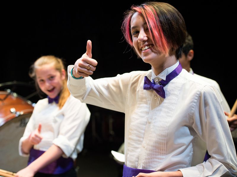 Two young musicians giving a thumbs up during a concert or recital