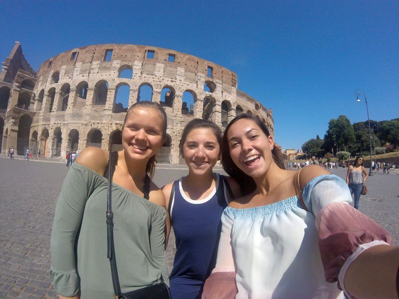 Three women taking a selfie at the Colosseum.