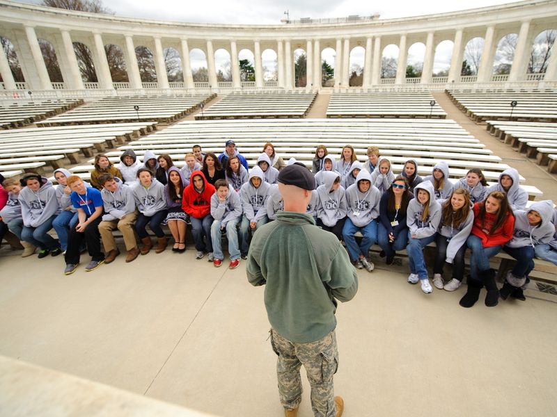 Students listening to a military speaker at a historical site near Arlington National Cemetery.