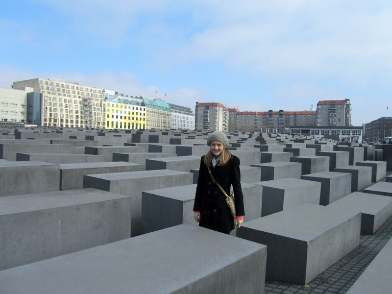 Young woman standing in the Memorial to the Murdered Jews of Europe in Berlin, Germany.