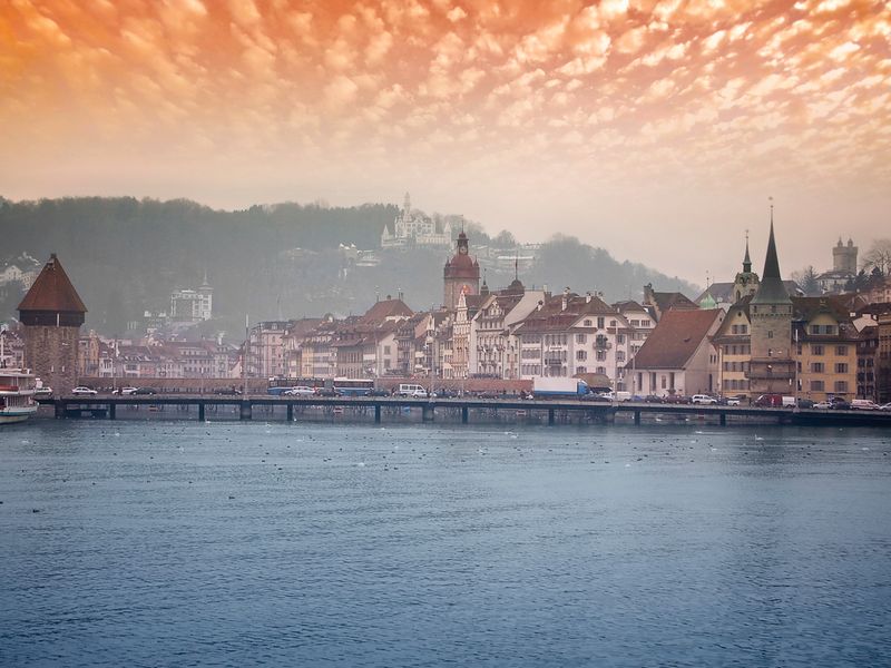 Lucerne city at sunset featuring Chapel Bridge over Lake Lucerne.