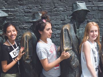 Teenagers posing with statues at the Franklin Delano Roosevelt Memorial