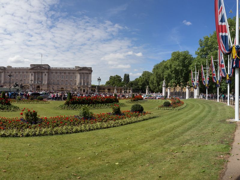 Buckingham Palace with tourists and locals gathered in front on a sunny summer day in London.