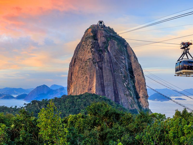 Cable car ascending Sugarloaf Mountain in Rio de Janeiro at sunset.