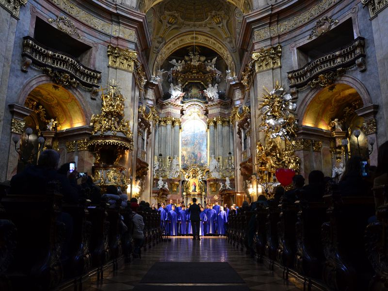 A choir in blue robes performs in a grand, ornate church, captivating the audience with their music.