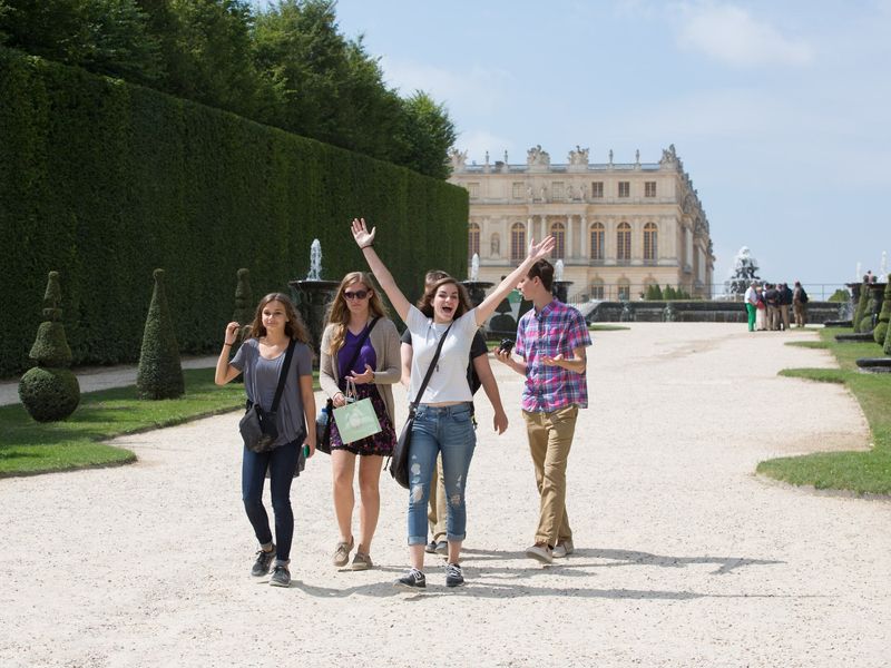 Five young adults visiting the Palace of Versailles.