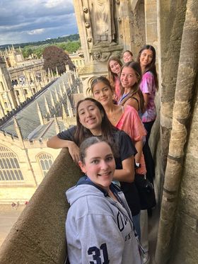 Group of teenage girls taking a selfie overlooking Oxford, England from a high vantage point.