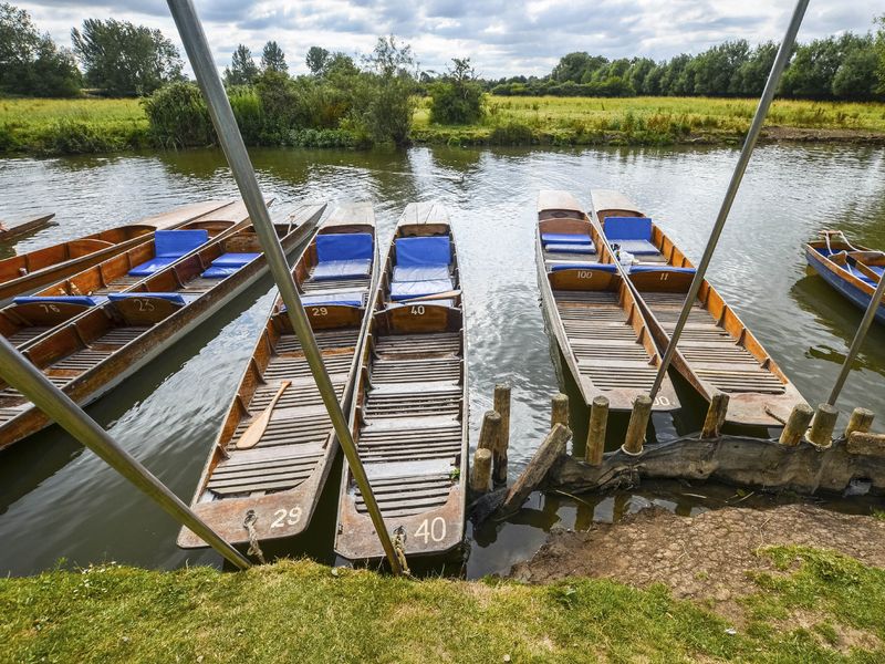 Several wooden punts tied to a dock on a river