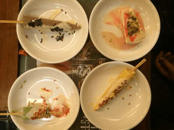 Four plates with a variety of Indian desserts on a table