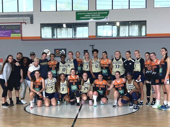 Group photo of the Melissia Wingate women's basketball team and coaches on an indoor court.