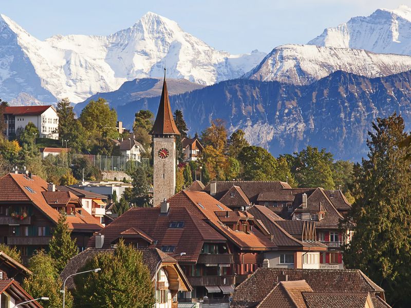 A picturesque Swiss village with the Swiss Alps in the background.