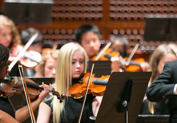 A youth orchestra performing on stage.