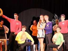 A group of young performers on stage during a theatrical production.