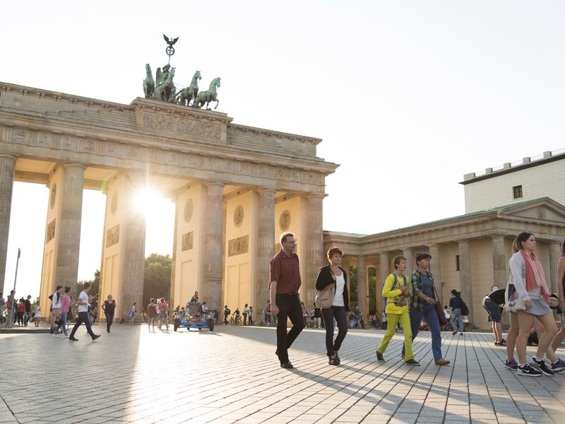 The Brandenburg Gate in Berlin, Germany with people walking through the Pariser Platz.