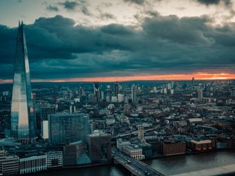 Aerial cityscape of London at sunset with The Shard skyscraper prominent.