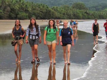 Group of teenagers and young adults walking on the beach in Drake Bay, Costa Rica