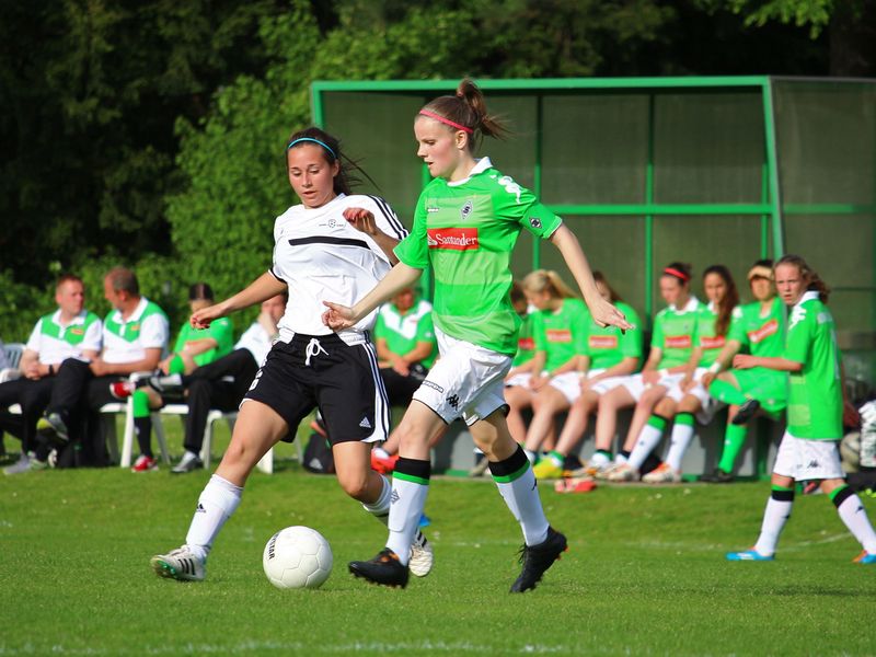 Two teenage girls playing in a soccer game