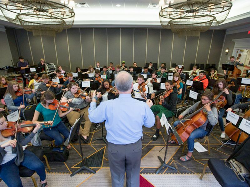 Conductor leading a youth orchestra