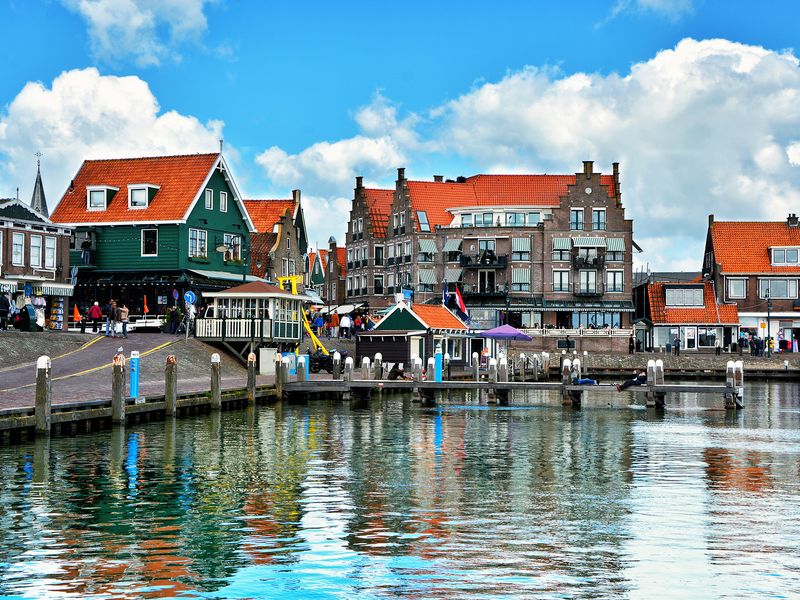 Picturesque waterfront scene with colorful buildings lining a harbor in Volendam, Netherlands.