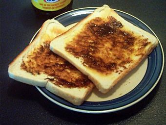 Two slices of toast with Vegemite spread on them.