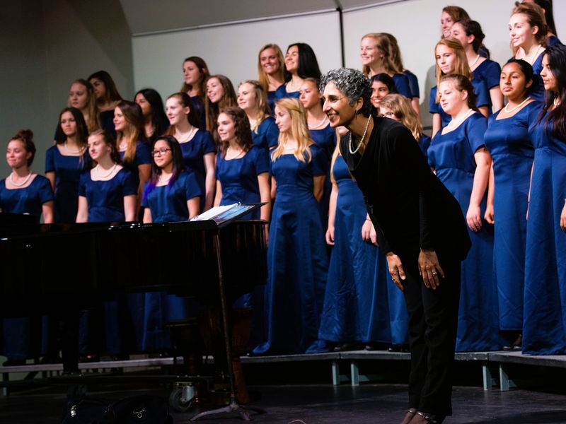 Choir director taking a bow with her choir