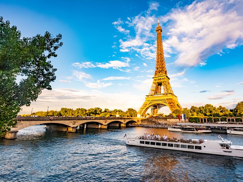 Eiffel Tower at sunset with tour boat on Seine River