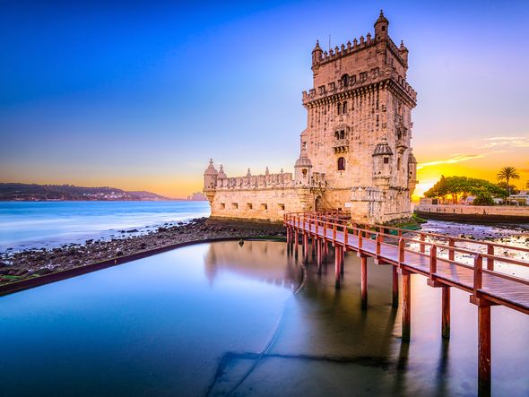 The Belém Tower in Lisbon, Portugal, bathed in the warm glow of the setting sun.