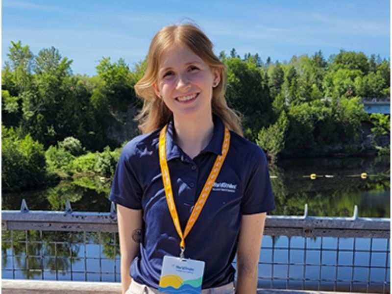 Smiling Woman by a River with Green Trees