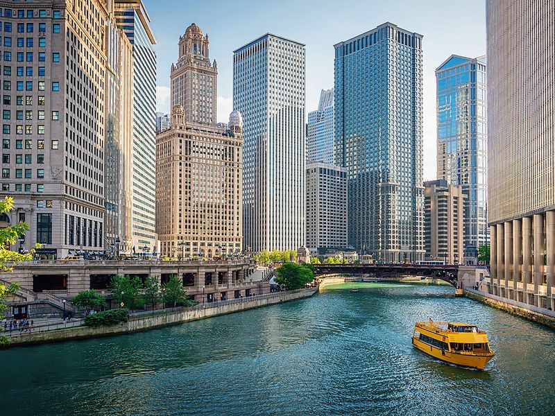 Scenic view of the Chicago Riverwalk and skyline with a water taxi.