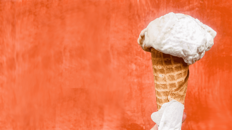 Melting ice cream cone on orange background