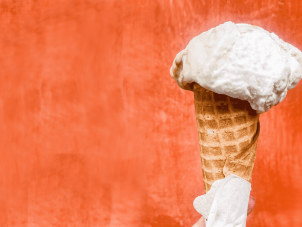 Melting ice cream cone on orange background